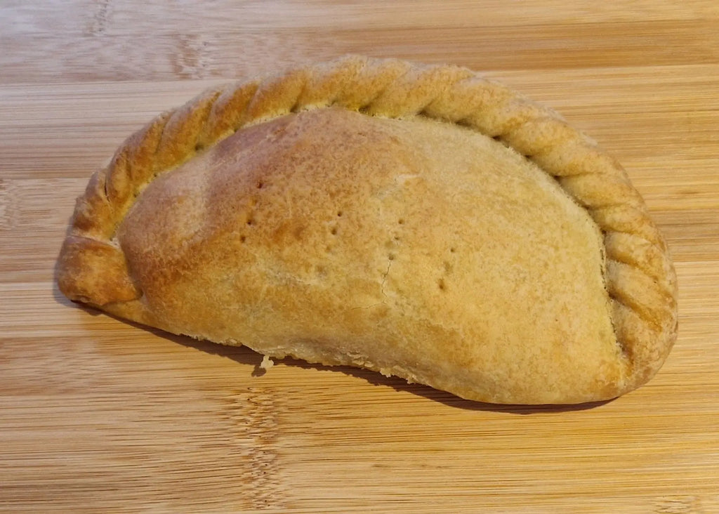 smoked vegan cheese pasty on a wooden surface. Vegan Pasties from the vegan pasty company