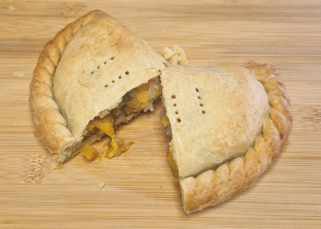vegan pasty cut in half showing vegan cheese melting inside.